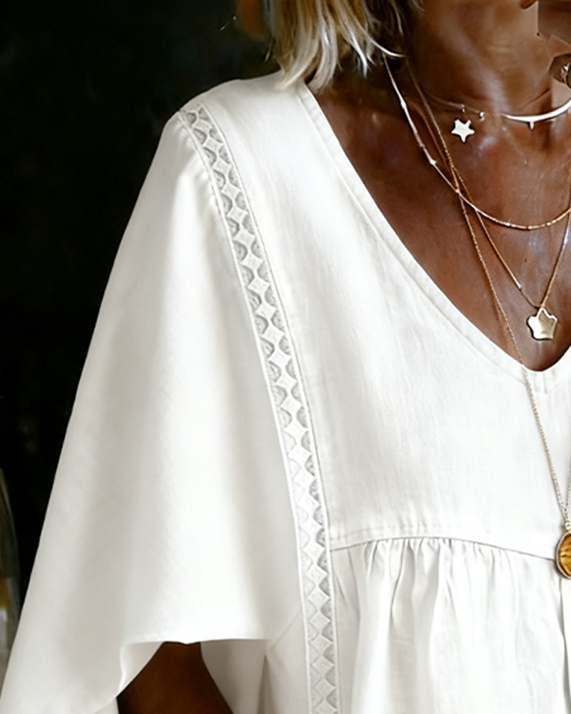 White cape style blouse with batwing sleeves, back view